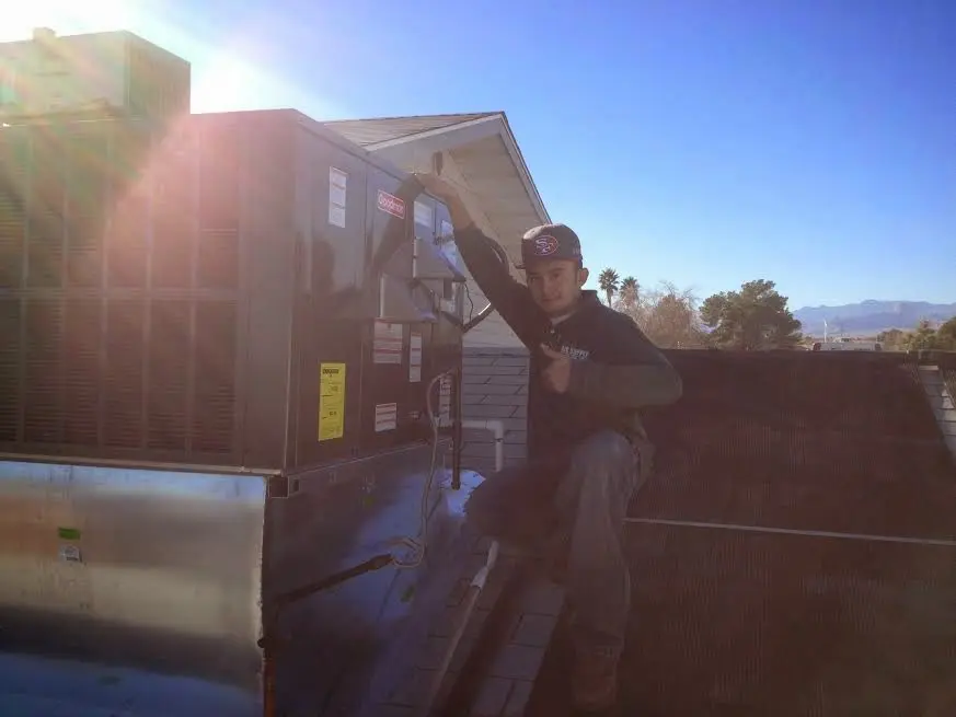 HVAC technician performing Air Duct Cleaning on a rooftop unit in Covedale